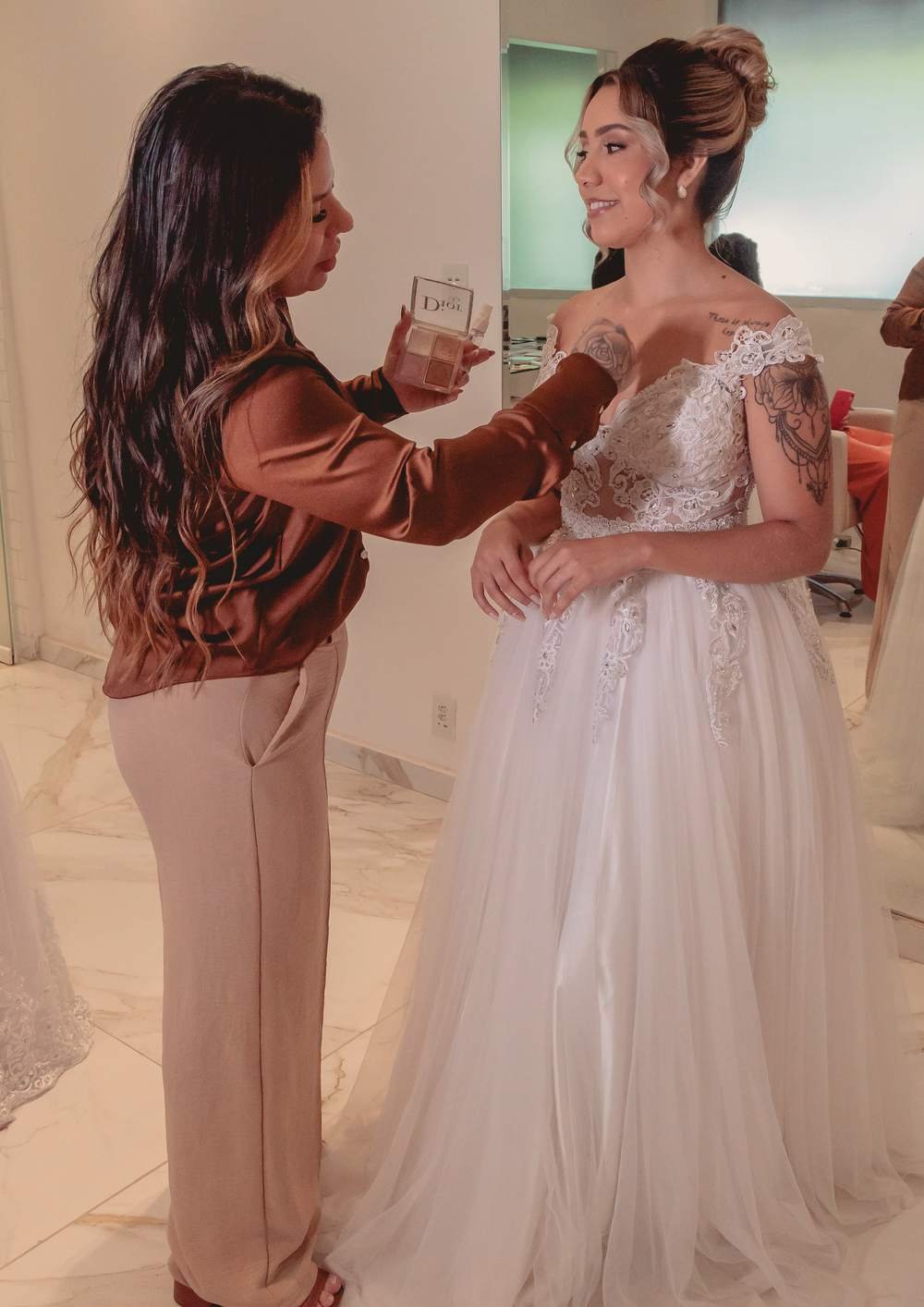 Rayenne finalizando a maquiagem de uma noiva